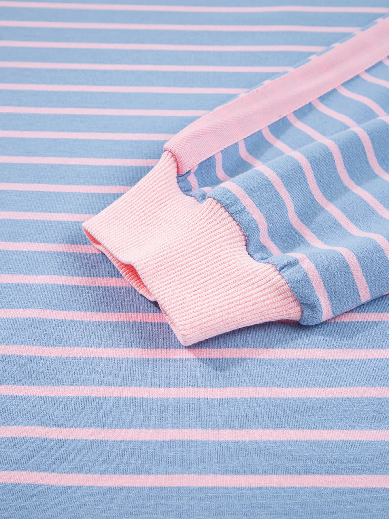Close-up of pink and blue striped fabric with a pocket on a matching background