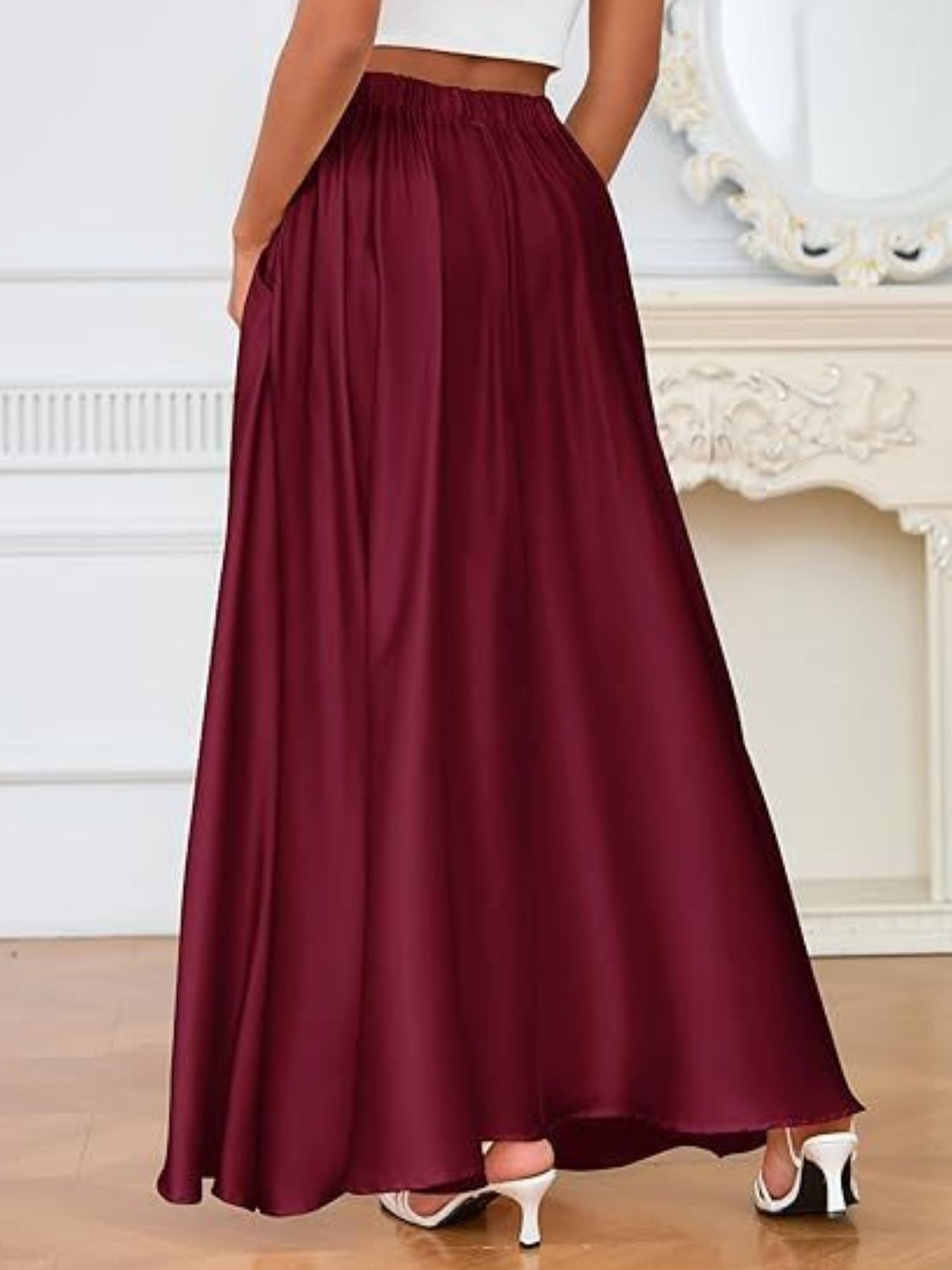Burgundy skirt worn by a person in a room with a decorative fireplace.