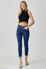 Woman wearing blue jeans and a black top on a white background