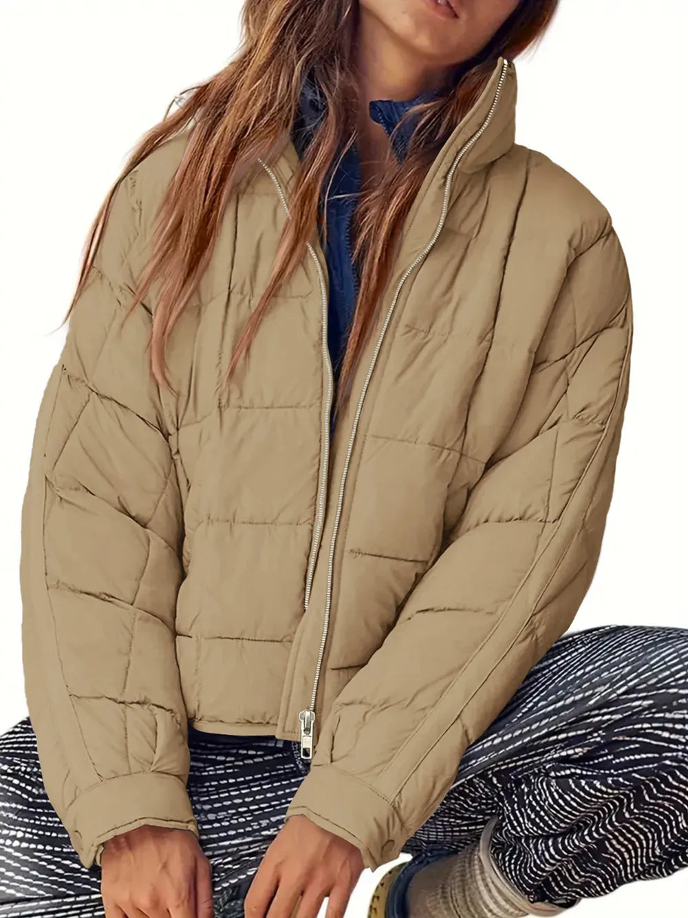 Person wearing a beige puffer jacket on a white background