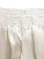 Close-up of a white garment with lace detailing on a white background