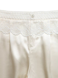 Close-up of a white garment with lace detailing on a white background