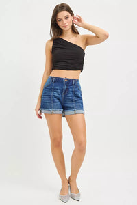 Woman wearing a black top and blue denim shorts on a white background