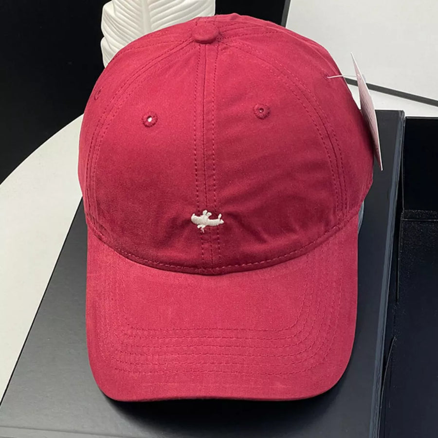 Red cap with a small logo on a black surface
