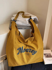 Yellow bag with 'Meaney' branding on a surface with books