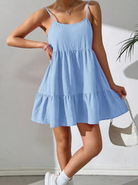 Person wearing a light blue dress against a plain background