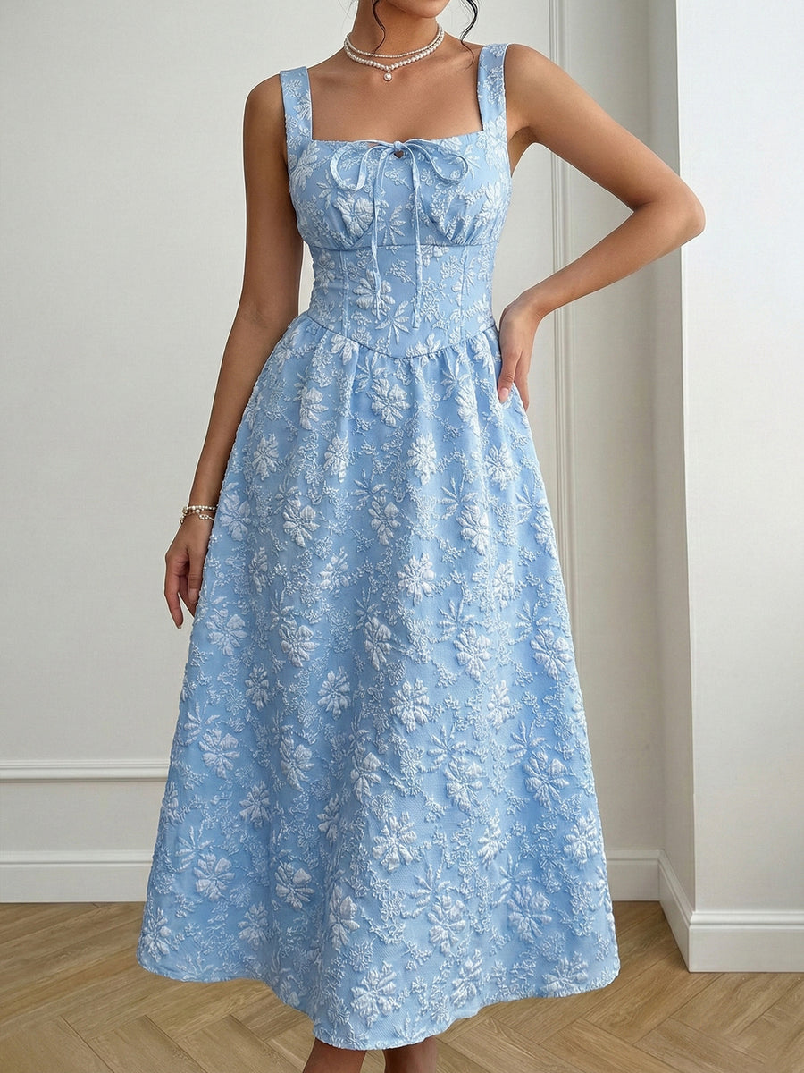 Woman wearing a blue floral dress against a neutral background
