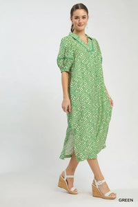 Woman wearing a green patterned dress on a white background