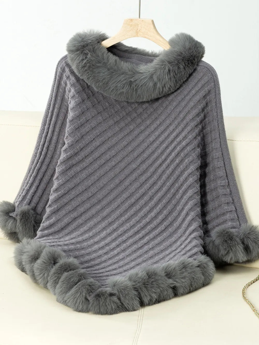 Gray poncho with fur trim on a white background