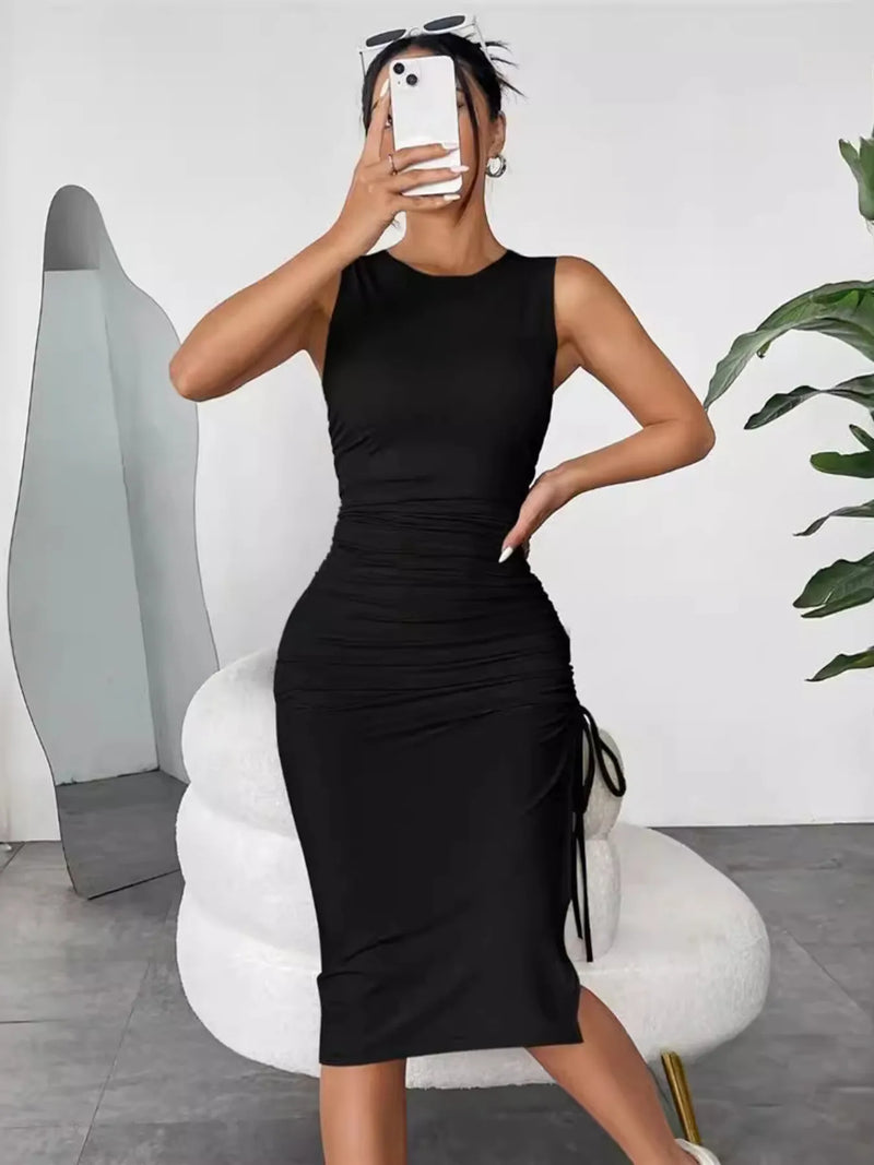Person wearing a black dress taking a mirror selfie in a modern interior setting.