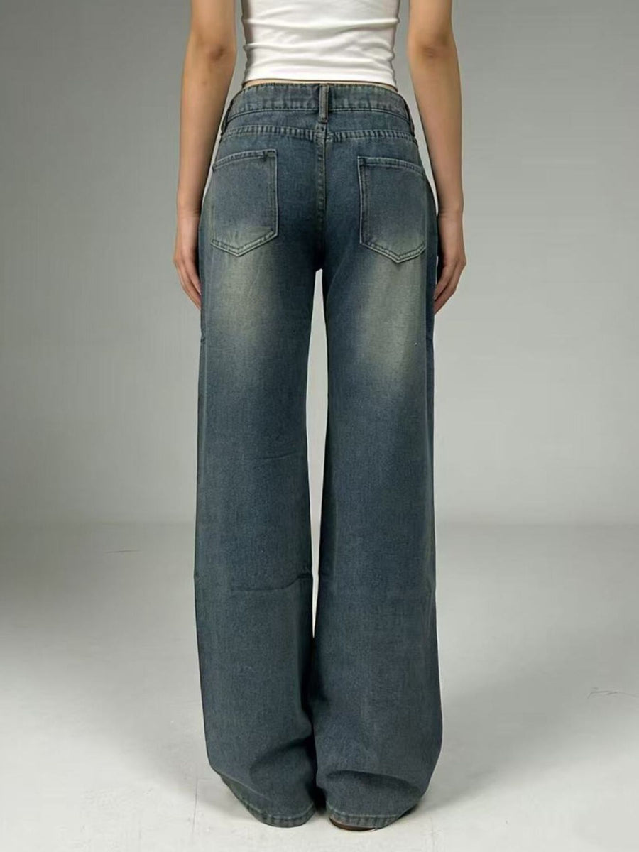 Person wearing wide-leg jeans on a plain background