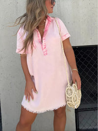 Woman wearing a pink and white dress with a neutral background