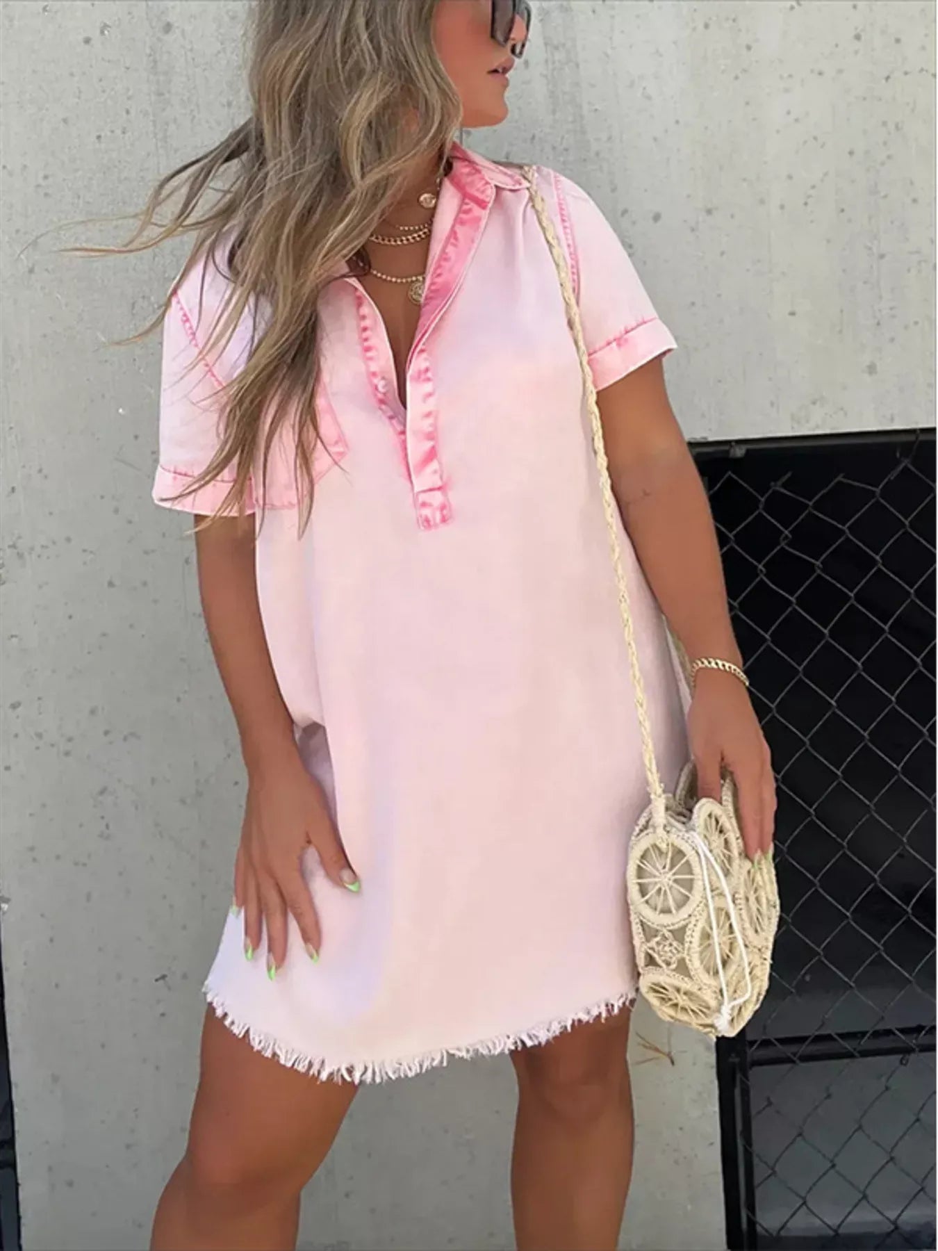 Woman wearing a pink and white dress with a neutral background