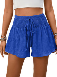 Blue shorts with a drawstring waist on a person against a white background