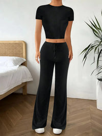 Person wearing a black outfit in a bedroom setting