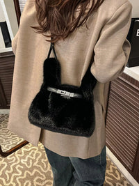 Person wearing a beige coat with a black fur-trimmed handbag.