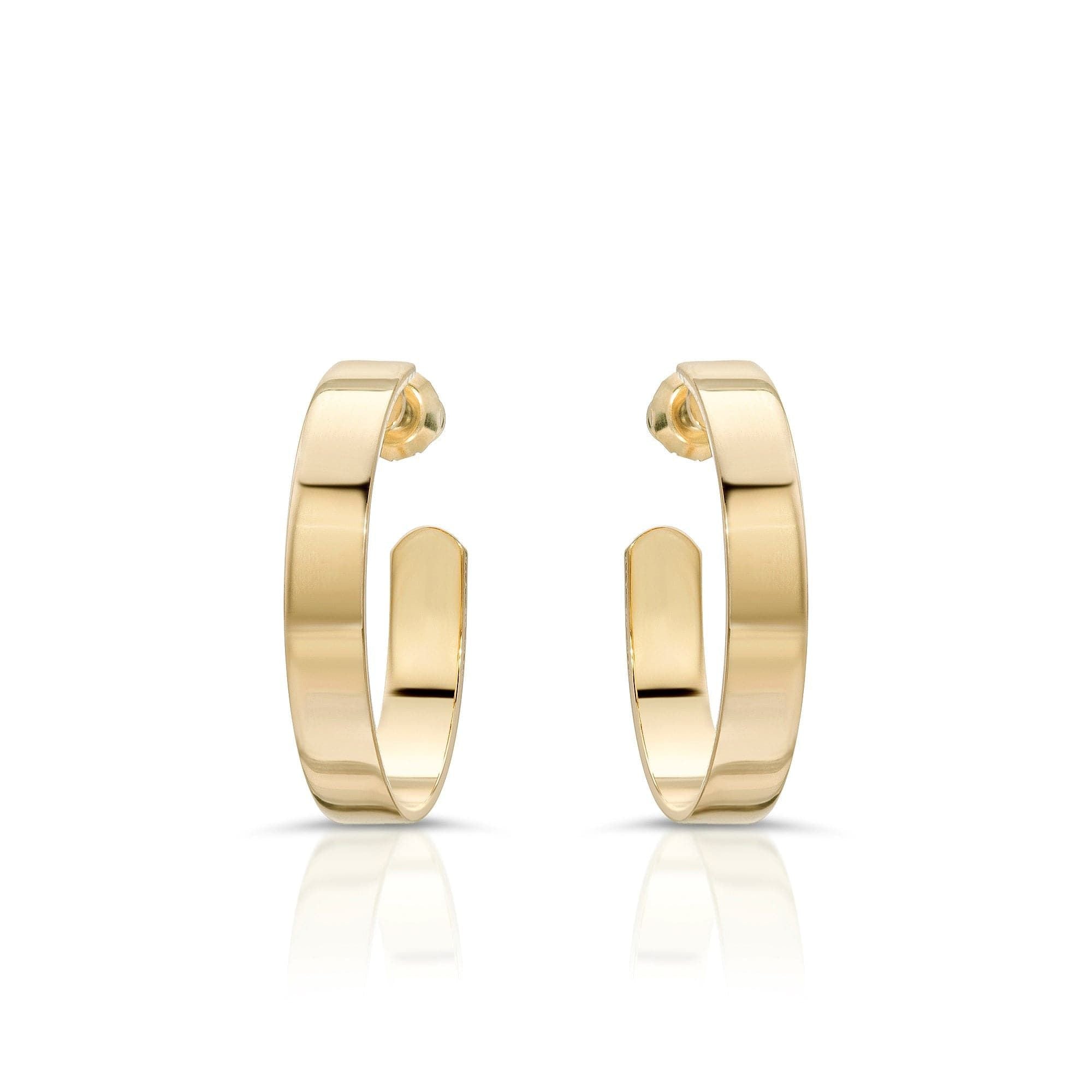 A pair of flat recycled brass hoop earrings with a 1 inch diameter, designed in a minimalistic style with a 14K yellow gold and rhodium finish.