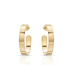 A pair of flat recycled brass hoop earrings with a 1 inch diameter, designed in a minimalistic style with a 14K yellow gold and rhodium finish.