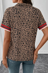 Leopard print shirt with red and green trim worn by a person against a neutral background