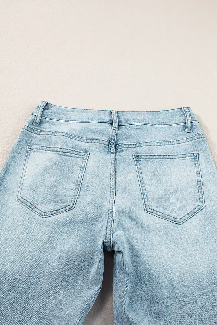Light blue jeans on a beige background