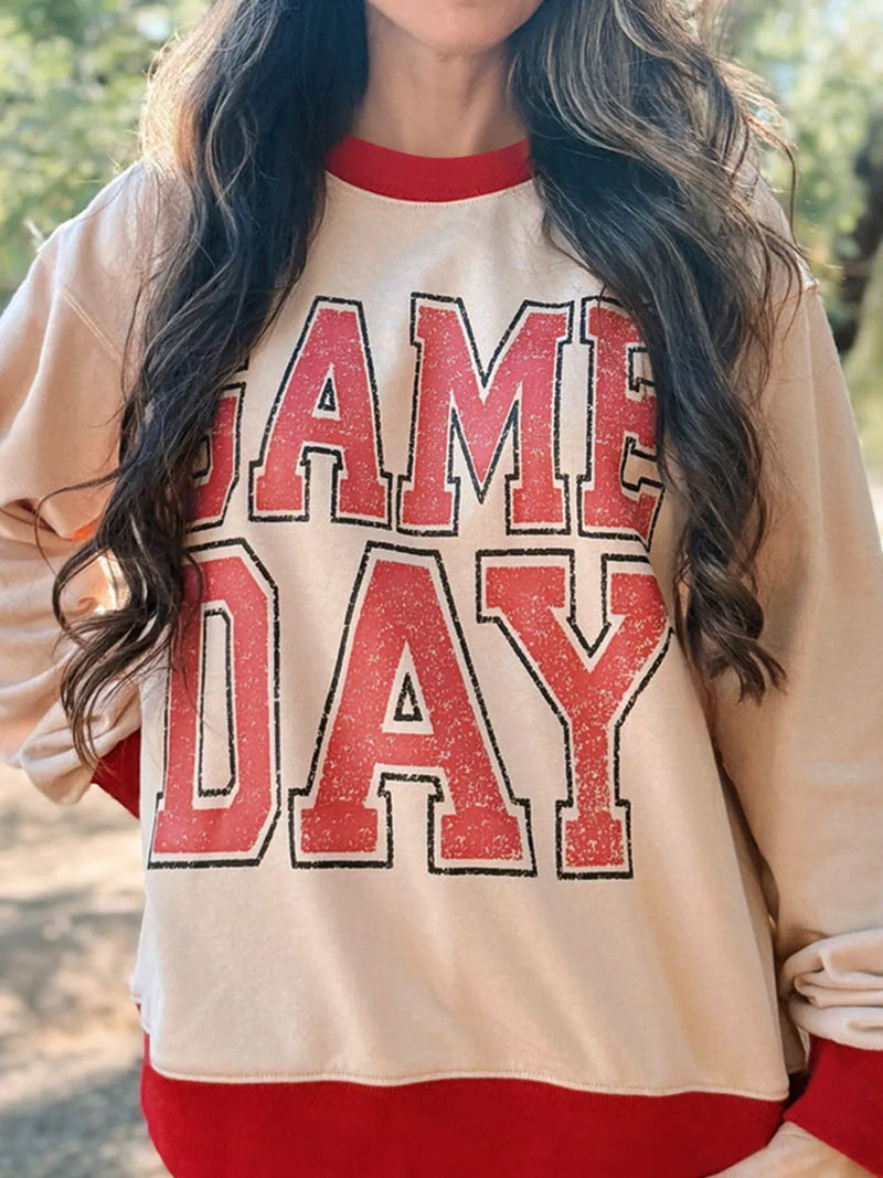 Person wearing a 'Game Day' sweatshirt with red and beige colors.