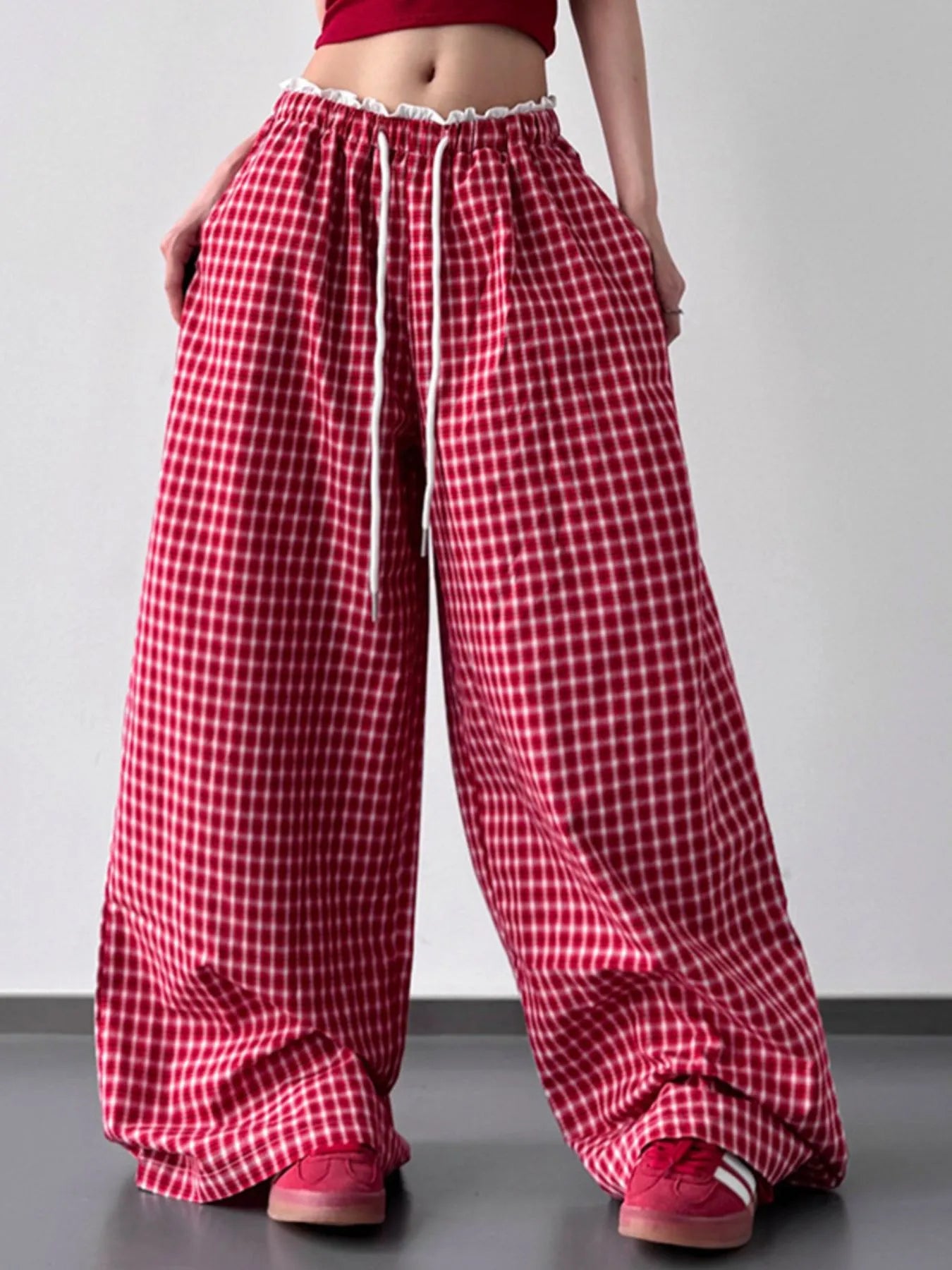Red checkered pants worn by a person on a plain background