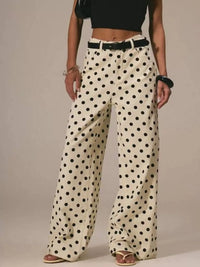 Person wearing polka dot pants with a plain background