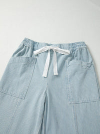 Light blue striped pants with a drawstring on a light gray background