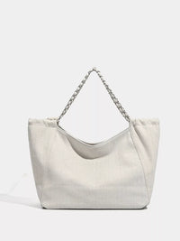 Light gray handbag with a chain detail on a light gray background