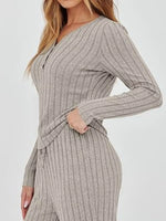 Woman wearing a gray ribbed jumpsuit on a white background