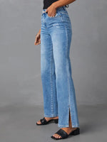 Person wearing light blue jeans with a gray background