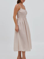 Woman wearing a beige striped dress on a white background