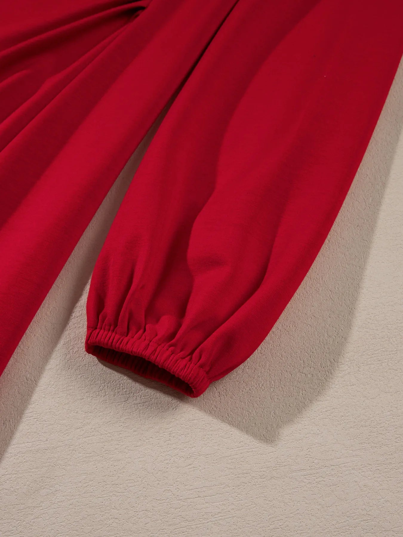 Red pants with elastic cuffs on a beige background