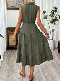 Woman wearing a green dress in a room with plants and furniture.