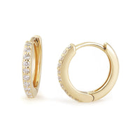 A pair of 14k gold huggie earrings with diamond accents