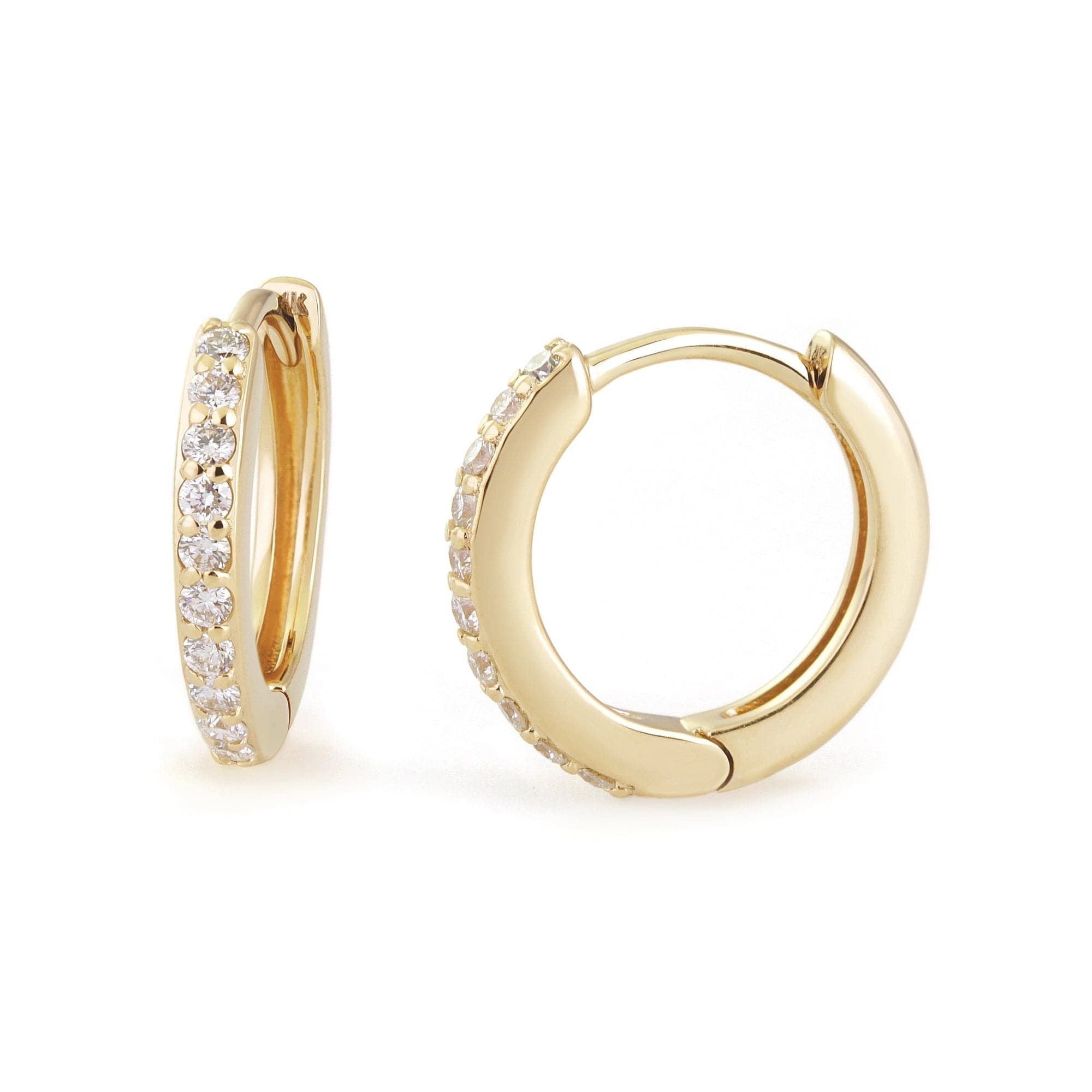 A pair of 14k gold huggie earrings with diamond accents