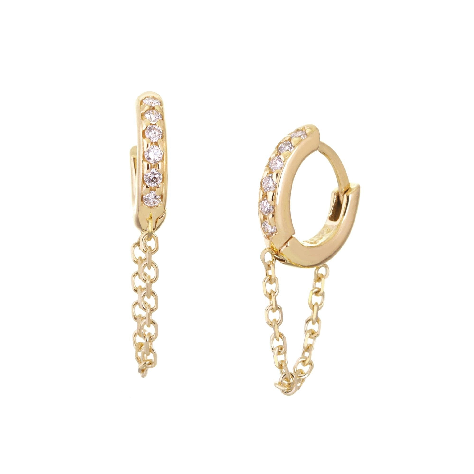 A pair of 14K gold huggie earrings with chain drops, studded with white diamonds.