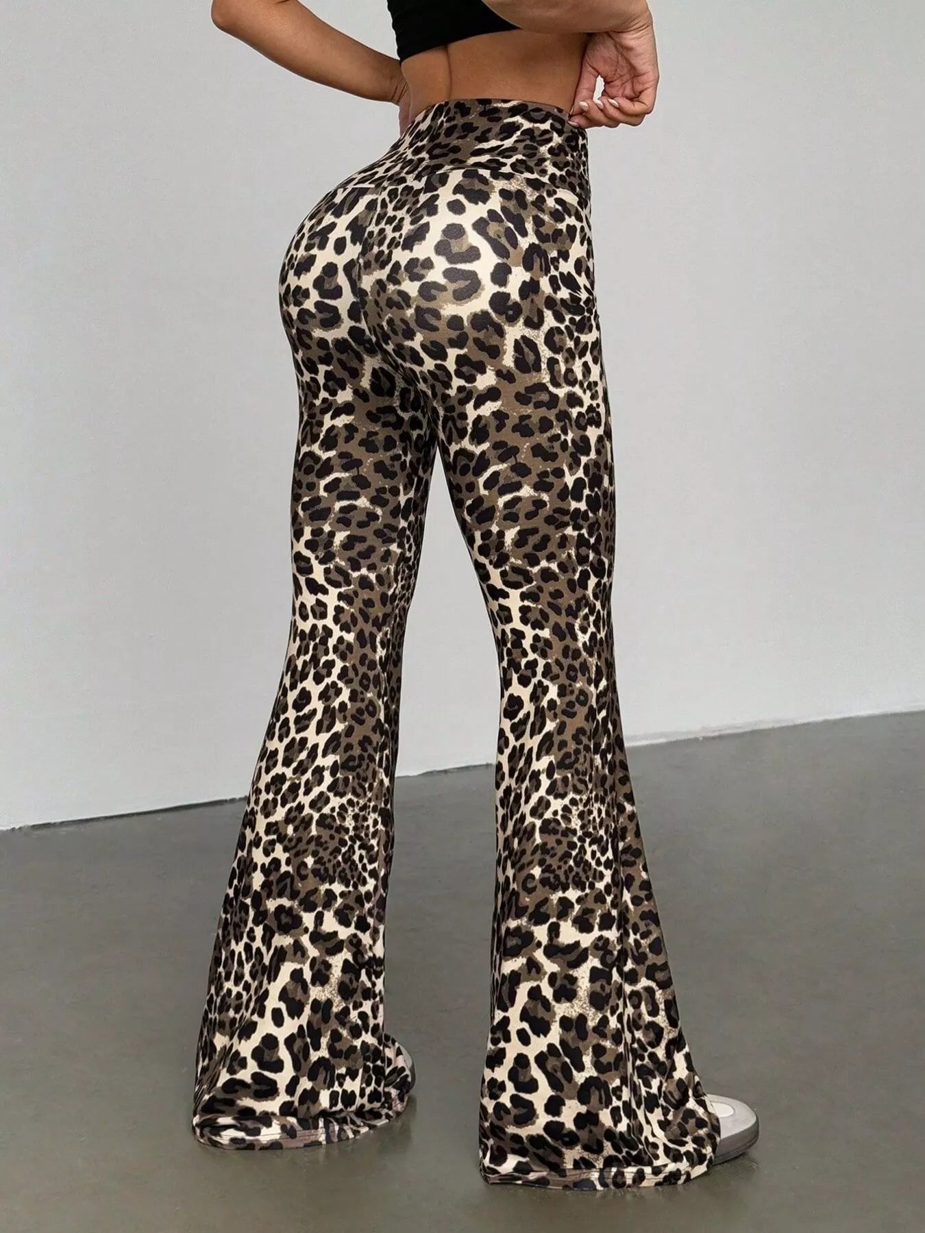 Leopard print flared pants worn by a person on a plain background