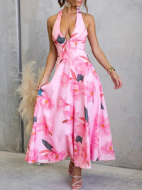 Woman wearing a pink floral dress against a gray wall.