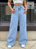 Person wearing light blue jeans with a building in the background