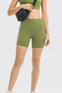 Person wearing green athletic shorts on a white background