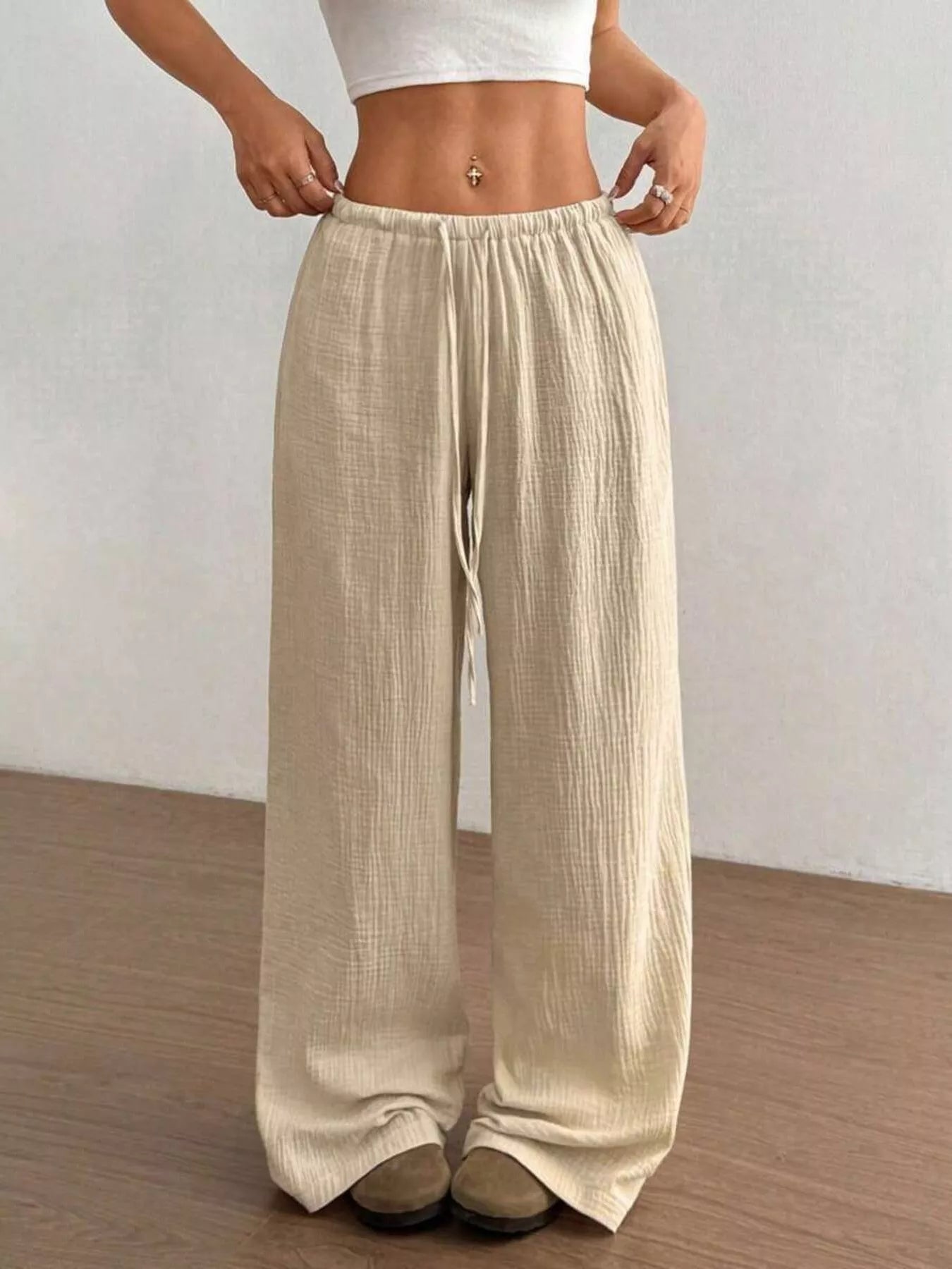 Beige wide-leg pants worn by a person on a plain background