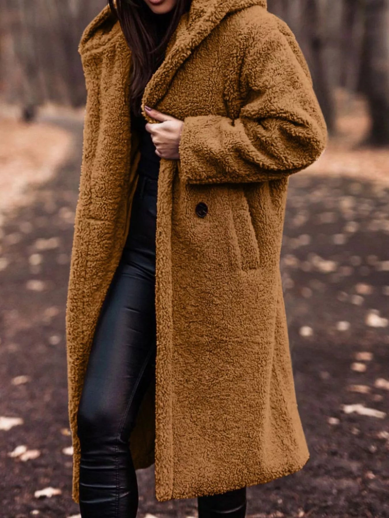 Person wearing a brown teddy coat in a forest setting
