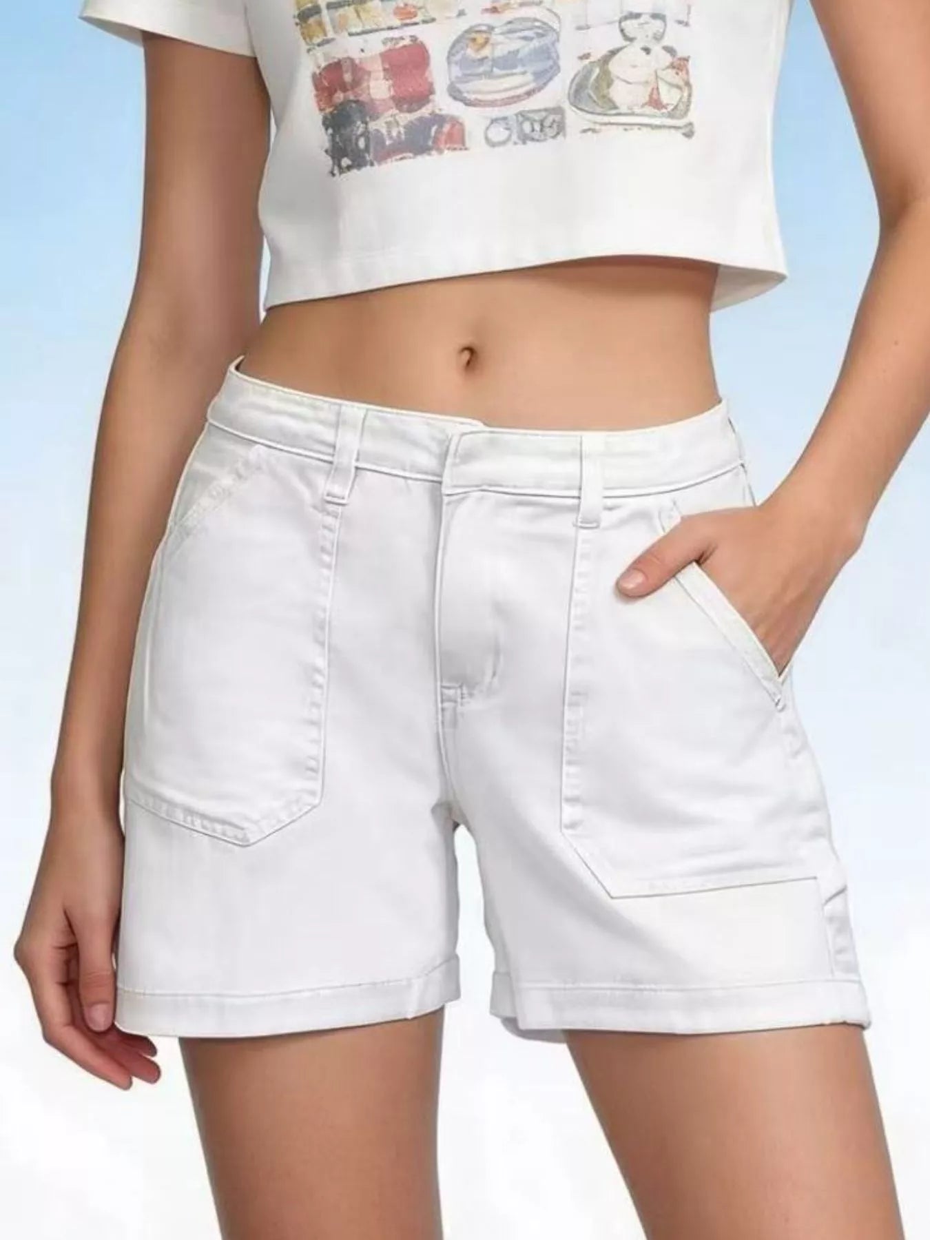 White denim shorts worn by a person on a light blue background