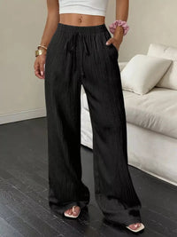 Person wearing black wide-leg pants in a living room setting
