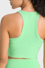 Green sports bra worn by a person on a light gray background