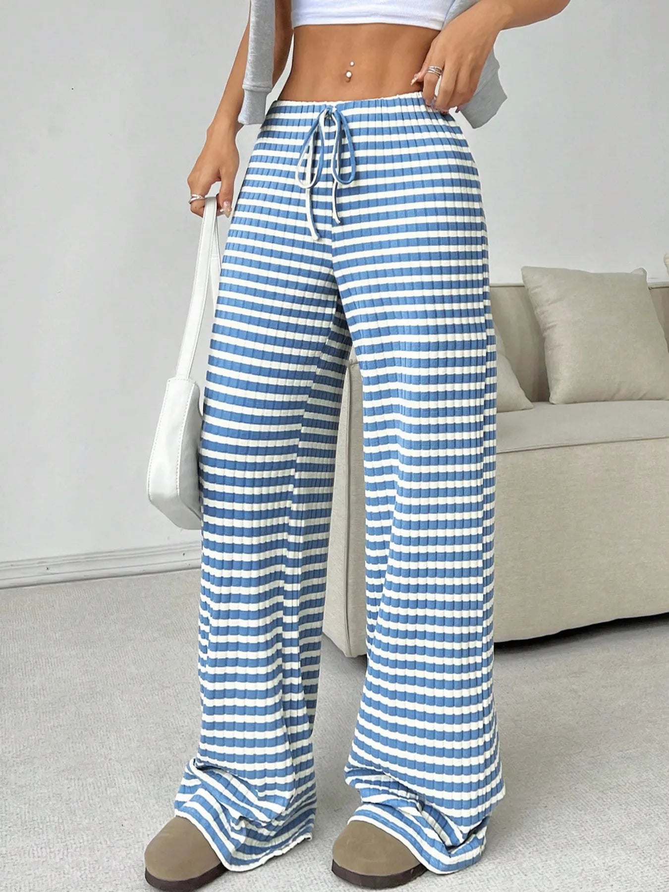 Person wearing blue and white striped pants in a casual setting.