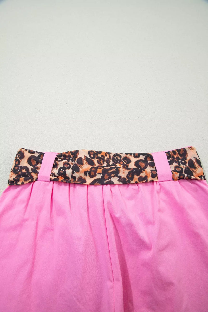 Pink skirt with a leopard print belt on a light gray background