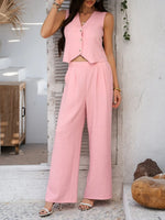 Woman wearing a pink outfit standing in a room with a white wall and wooden cabinet.