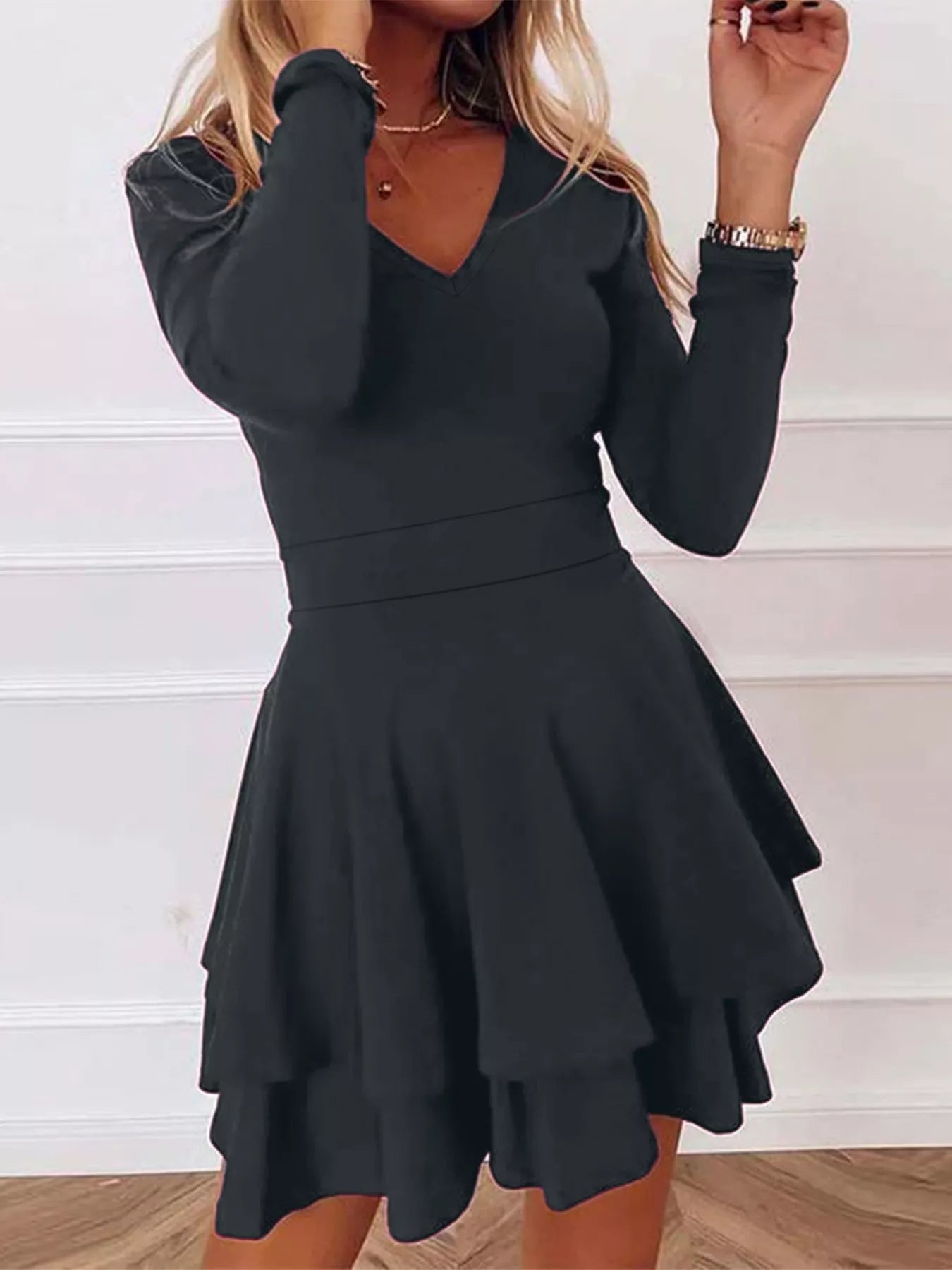 Black dress with long sleeves and a flared skirt on a white background